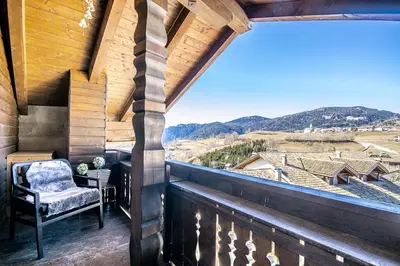 a balcony with a chair and a view of the mountains at Ferienhaus Winkler in Anterivo