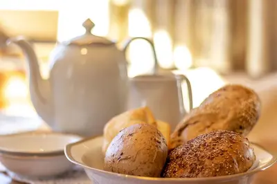 a bowl of muffins on a table with a tea kettle at Ferienhaus Winkler in Anterivo