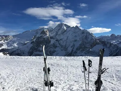 a pair of skis in the snow in front of a mountain at Chalet Tobià Apartments in Canazei