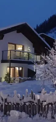 a house in the snow with snowmen in front of it at Chalet Tobià Apartments in Canazei