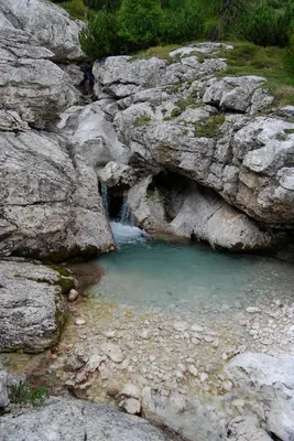 a small pool of water in a rocky canyon at Chalet Tobià Apartments in Canazei