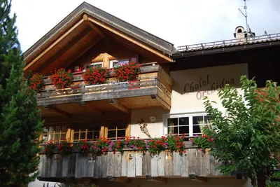 a building with flower boxes on a balcony at Chalet Tobià Apartments in Canazei