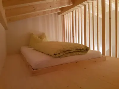 a bed in a room under a stair case at El Paradiso in Naturno