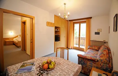 a living room with a table and a couch at Pension Laurin in Schenna