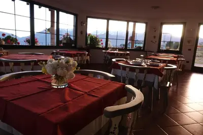 a restaurant with tables and chairs with red table cloth at La Capannina in Coredo