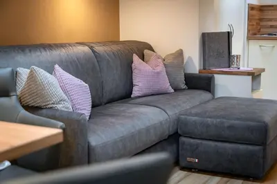a living room with a gray couch and a ottoman at Living Puez in Funes