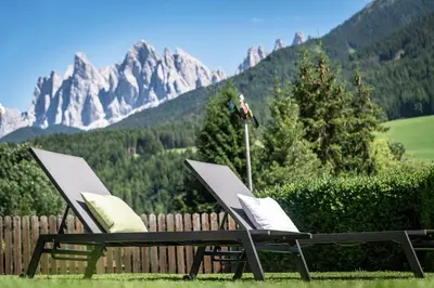 two chairs and a table with mountains in the background at Living Puez in Funes