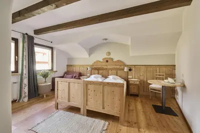 a bedroom with a large bed and a table at Haus Tirol in Molini di Tures