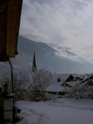 a view of a snow covered town with a church at Haus Tirol in Molini di Tures