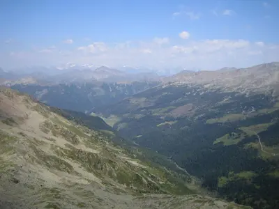 a view of a mountain valley with trees and mountains at Biohof Hamann in Sarntal