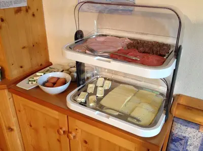 a refrigerator filled with meat cheese and other foods at Biohof Hamann in Sarntal