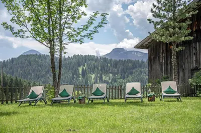a group of chairs sitting in the grass at Hotel Bewaller in Obereggen