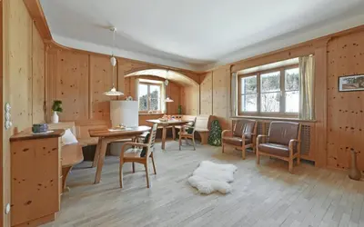 a living room with wooden walls and a table and chairs at Hotel Bewaller in Obereggen