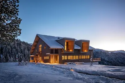 a house in the snow at dusk at Hotel Bewaller in Obereggen