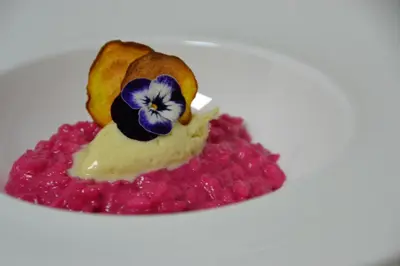 a white plate with a dessert with a flower on it at Almhotel Bergerhof in Sarntal