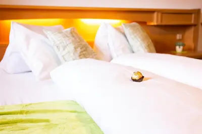 a engagement ring sitting on top of two white beds at Almhotel Bergerhof in Sarntal