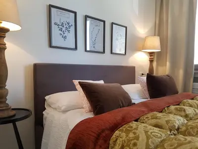 a bedroom with two beds and three pictures on the wall at Your secret place to stay - Therme Meran in Merano