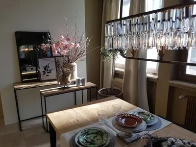 a dining room with a table and a chandelier at Your secret place to stay - Therme Meran in Merano
