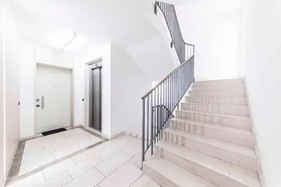 a staircase in a white room with a white wall at Stay COOPER l Cà de Bezzi in Bolzano