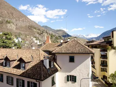 a group of buildings with mountains in the background at Stay COOPER l Cà de Bezzi in Bolzano