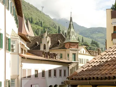 a group of buildings with a mountain in the background at Stay COOPER l Cà de Bezzi in Bolzano