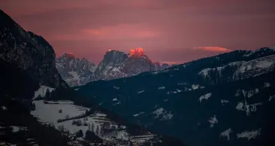 a view of a mountain range with the moon in the sky at La Roccia Wellness Hotel in Cavalese