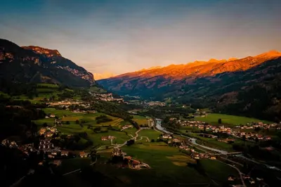 a view of a town in the mountains at night at La Roccia Wellness Hotel in Cavalese