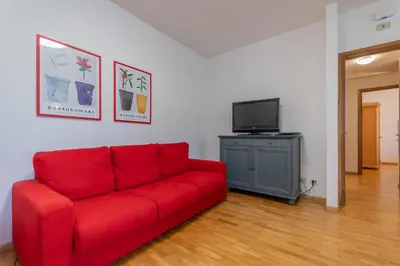 a red couch in a living room with a tv at Villa Licia in Falcade