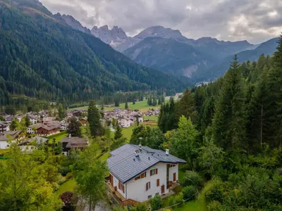 a village in a valley with mountains in the background at Villa Licia in Falcade