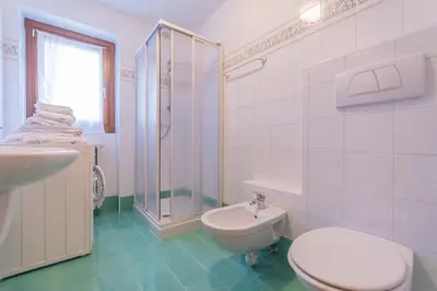 a bathroom with a toilet and a shower and a sink at Villa Licia in Falcade