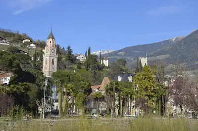 a building with a clock tower on a hill at Appartment Trojer in Merano