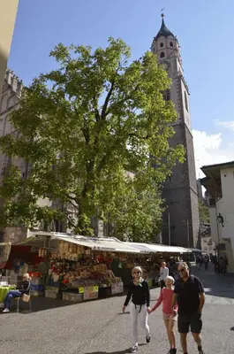 a group of people walking down a street near a market at Appartment Trojer in Merano