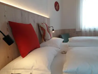 a room with two beds with red and white pillows at CHALET MARLENE - Ferienhaus in San Vigilio Di Marebbe