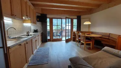 a kitchen with a couch and a table in a room at CHALET MARLENE - Ferienhaus in San Vigilio Di Marebbe