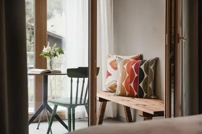 a room with a bench and a chair and a window at CHALET MARLENE - Ferienhaus in San Vigilio Di Marebbe