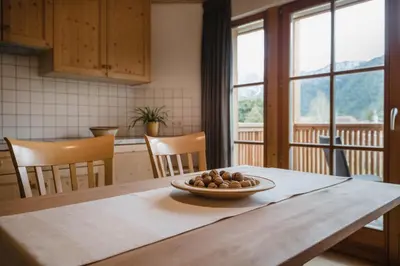 a kitchen table with a bowl of fruit on it at CHALET MARLENE - Ferienhaus in San Vigilio Di Marebbe