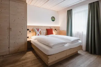 a bedroom with a bed and a window at CHALET MARLENE - Ferienhaus in San Vigilio Di Marebbe