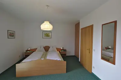 a bedroom with a large bed and a chandelier at Weingut Hochleiten in Caldaro
