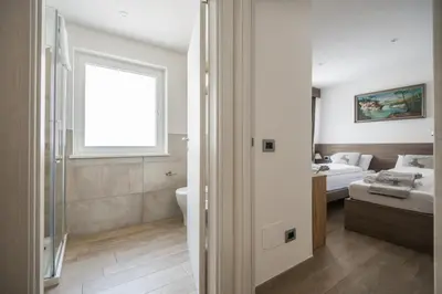 a bathroom with a toilet and a bed in a room at Piccola Cesa Apartments in Canazei