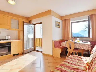a kitchen and living room with a table and a dining room at Apartment Lazzer-1 by Interhome in Campitello