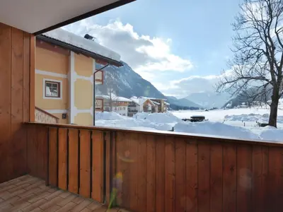 a snow covered building in front of a mountain at Apartment Lazzer-1 by Interhome in Campitello