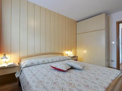 a bedroom with a large bed with red curtains at Apartment Lazzer-1 by Interhome in Campitello