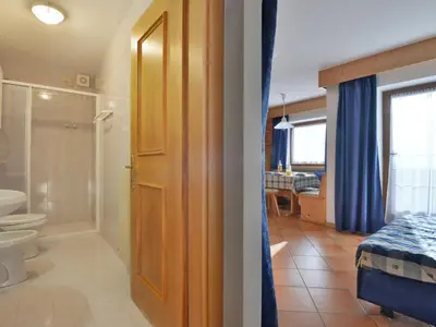a bedroom with a white bed and a window at Apartment Lazzer-2 by Interhome in Campitello