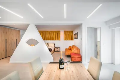 a white living room with a table and a couch at Fior Apartments Lofts in Merano