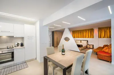 a kitchen and living room with a table and chairs at Fior Apartments Lofts in Merano