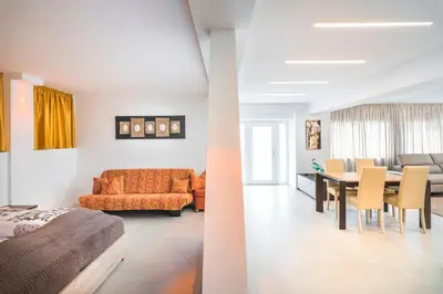 two views of a living room and a dining room at Fior Apartments Lofts in Merano