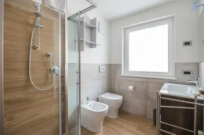 a bathroom with a shower and a toilet and a sink at Piccola Cesa B&B in Canazei