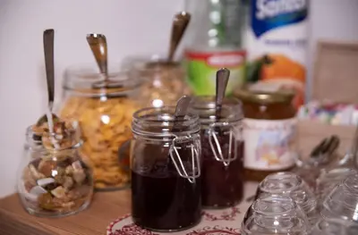 a wooden counter with jars of food and nuts at Piccola Cesa B&B in Canazei