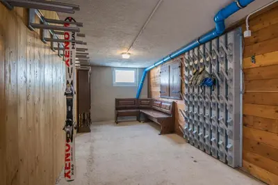 a room with a wall of hockey equipment in a room at Piccola Cesa B&B in Canazei