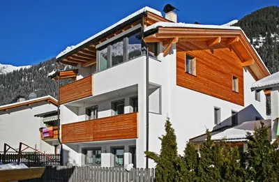 a house in the mountains with wooden balconies at Ferienwohnung Haus Reider in Sarntal